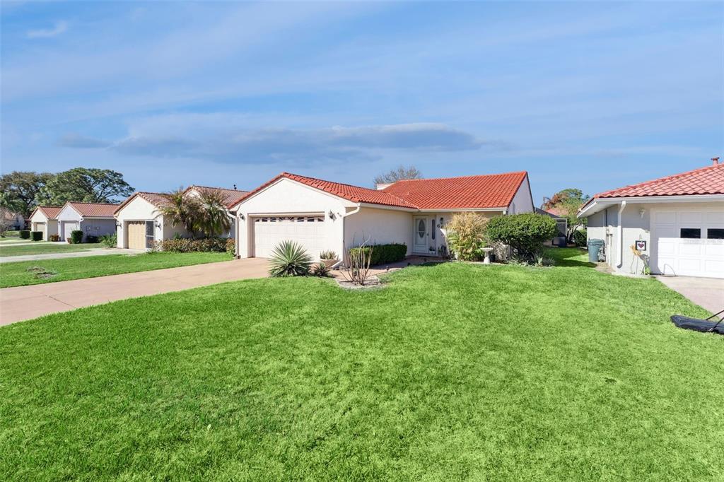 A single-story house with a two-car garage, a red tile roof, and a concrete driveway — 688 AUGUSTA ROAD, WINTER HAVEN, FL