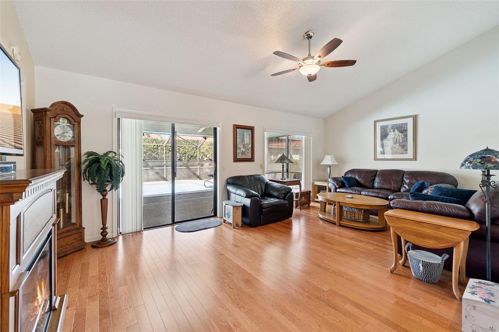 A living room features hardwood floors, a fireplace, a ceiling fan, and sliding glass doors — 688 AUGUSTA ROAD, WINTER HAVEN, FL