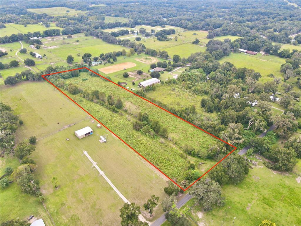 An aerial view shows a rectangular plot of land outlined in red amidst rural fields — 13844 NW 21ST COURT, CITRA, FL