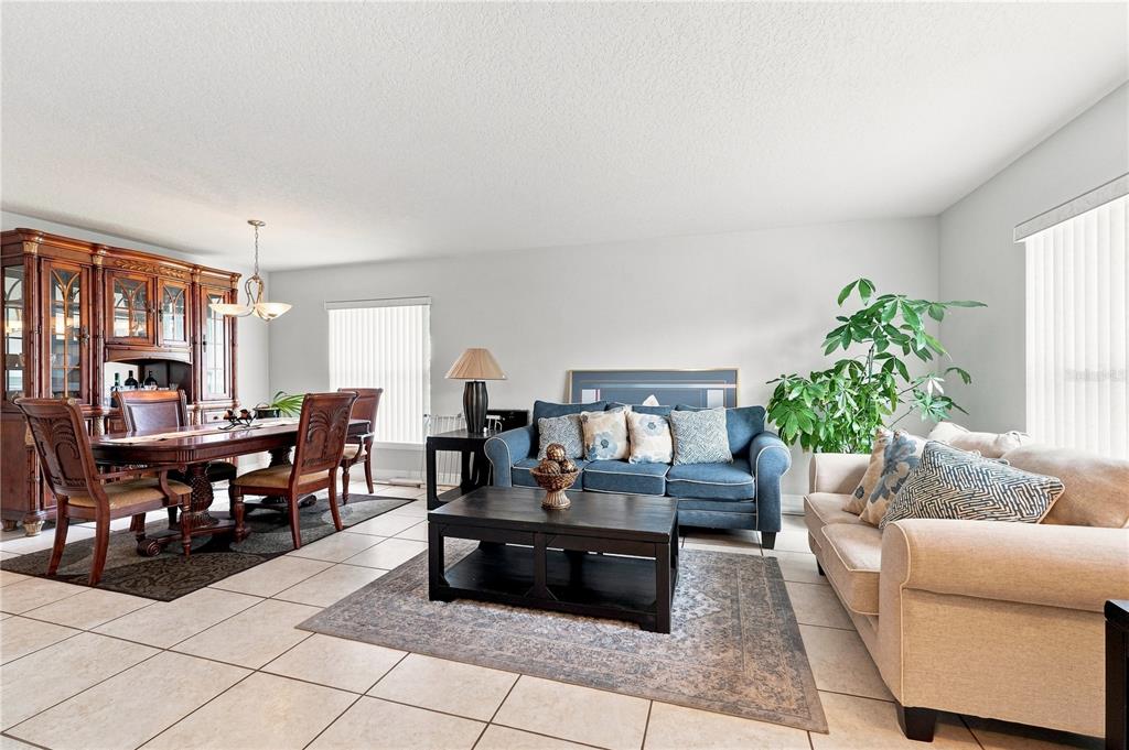 A living and dining room area features tile flooring, a dark wood dining set, and sofas — 2512 ABACUS COURT, LAKE MARY, FL