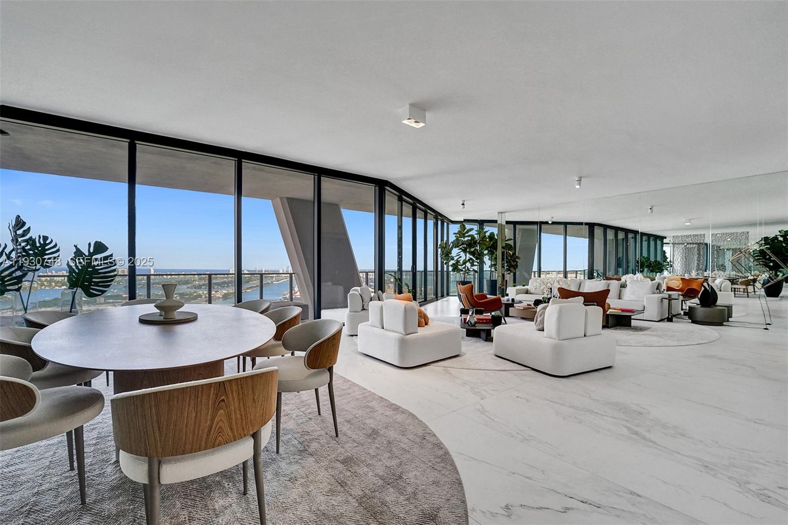 A spacious, open-concept living and dining area features marble floors, floor-to-ceiling windows, and water views — 1000 Biscayne Blvd # 3902, Miami FL 33132, MIAMI, FL