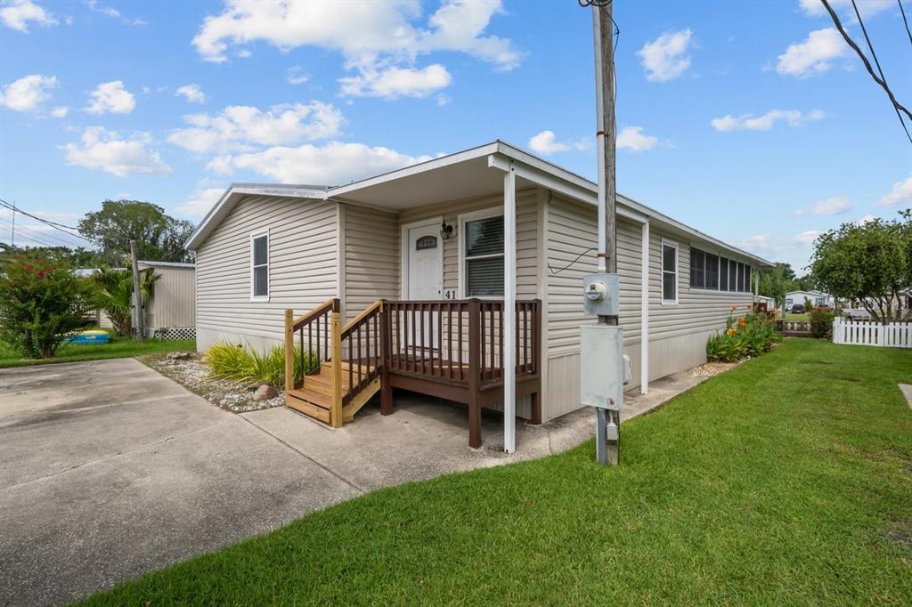 A beige mobile home with a small wooden porch and a concrete driveway — 41 SCOTT STREET, WELAKA, FL
