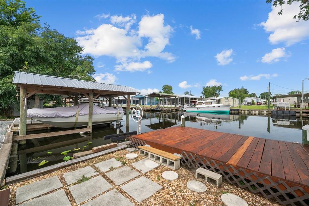 A boat dock with a covered slip and a wooden deck sits on a canal — 41 SCOTT STREET, WELAKA, FL