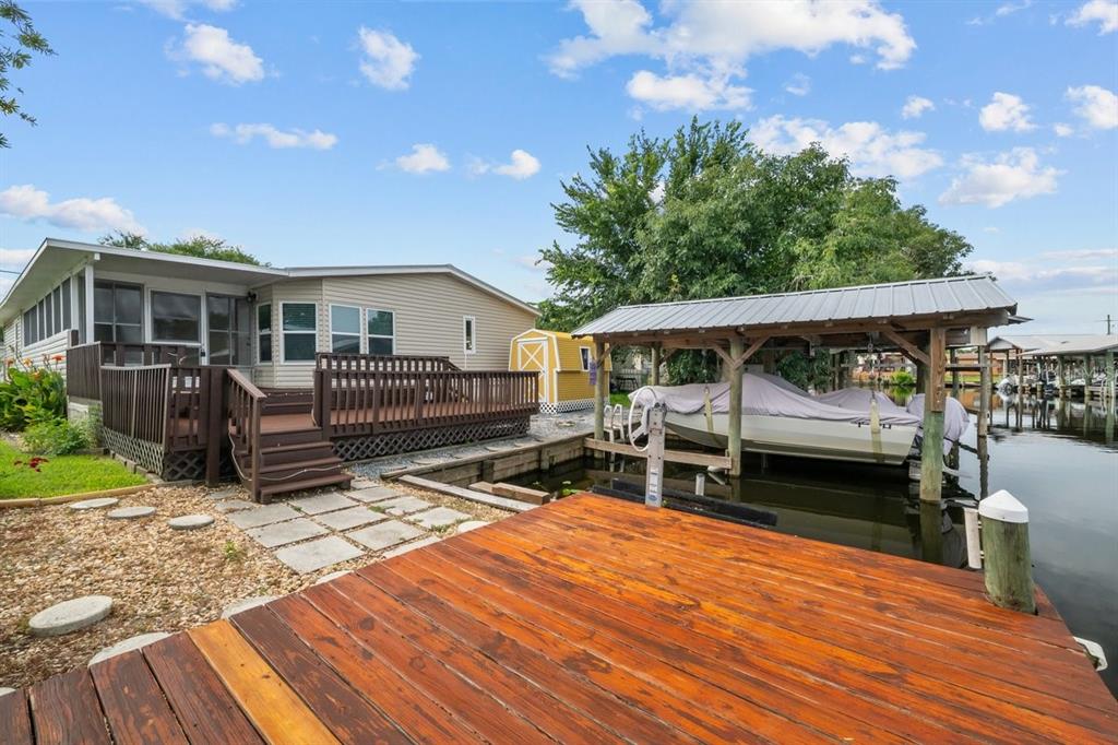 A waterfront house with a wooden deck, a boat slip, and a small yellow shed — 41 SCOTT STREET, WELAKA, FL