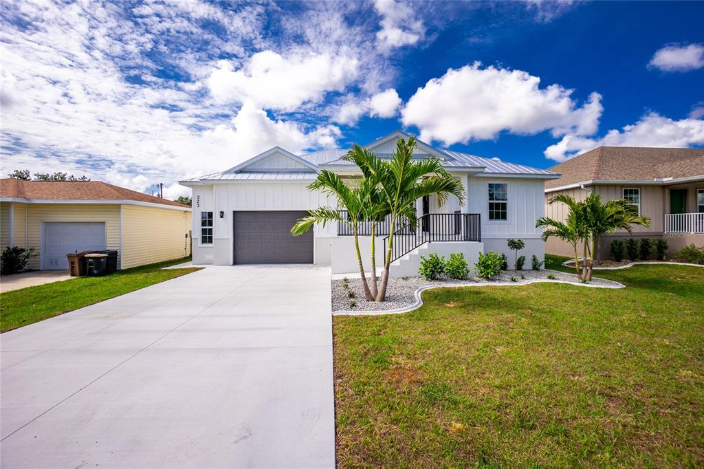 A white house with a gray garage and a palm tree in the front yard — 323 BOCA GRANDE BOULEVARD, PUNTA GORDA, FL