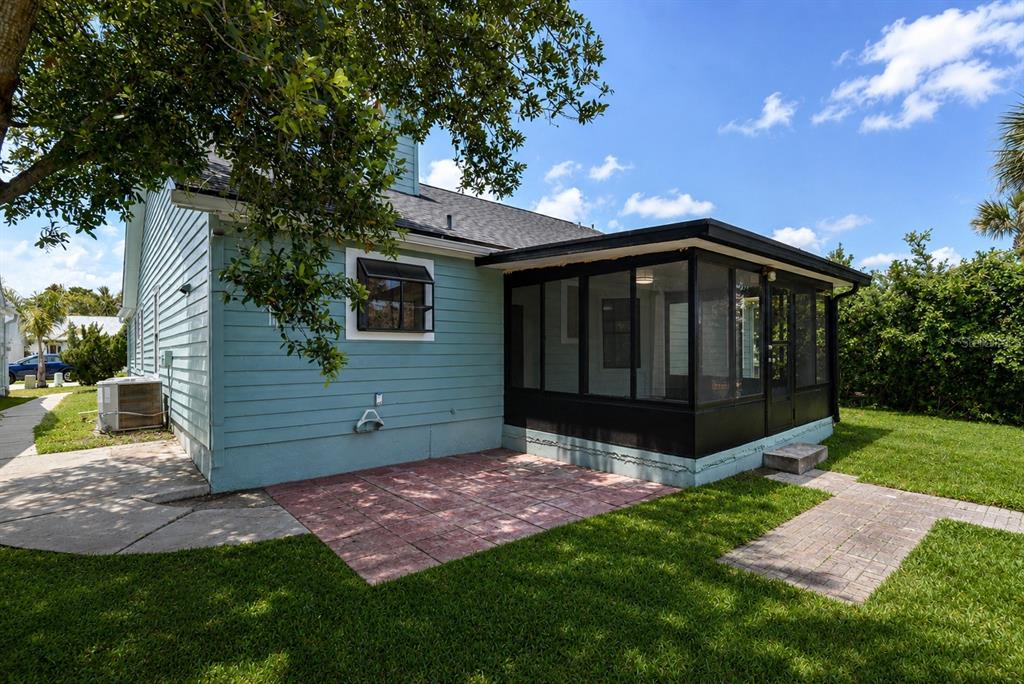 A light blue house features a black-framed screened-in porch and a red brick patio — 756 PINE SHORES CIRCLE, NEW SMYRNA BEACH, FL