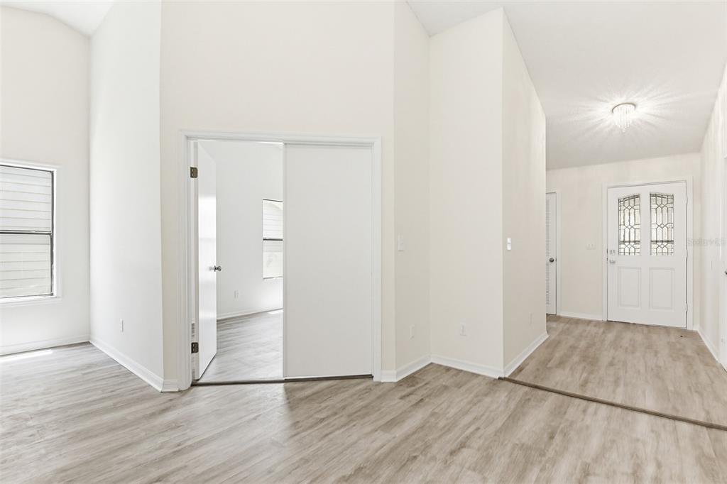 An interior view shows a room with light wood-look flooring, white walls, and sliding doors — 756 PINE SHORES CIRCLE, NEW SMYRNA BEACH, FL