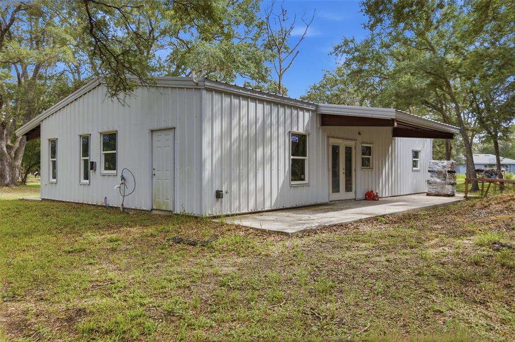 A single-story metal building with a concrete patio and a covered porch area — 18127 CEDARHURST ROAD, ORLANDO, FL