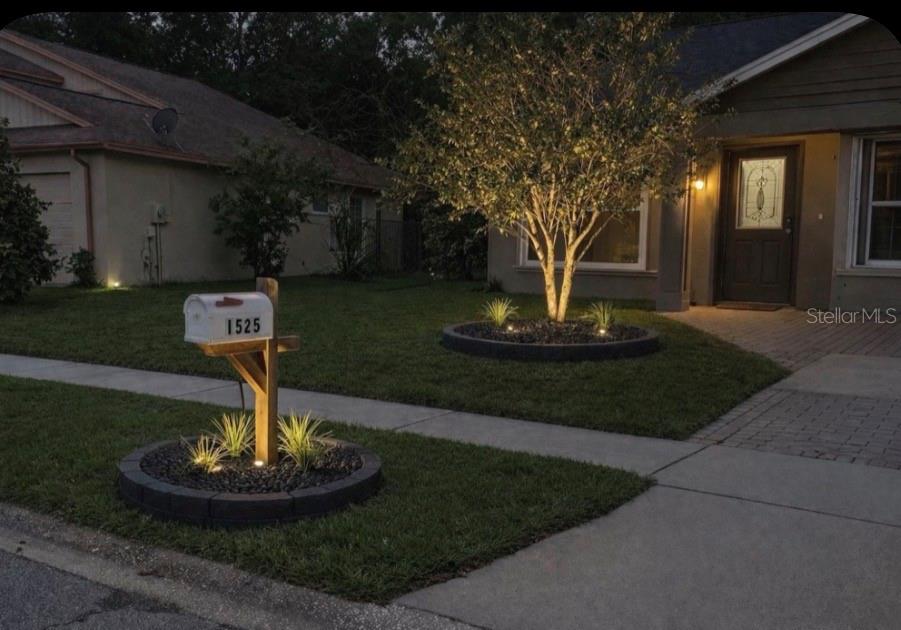A front yard features a mailbox and a tree, both surrounded by circular stone planters — 1525 KESTREL WAY, BRANDON, FL