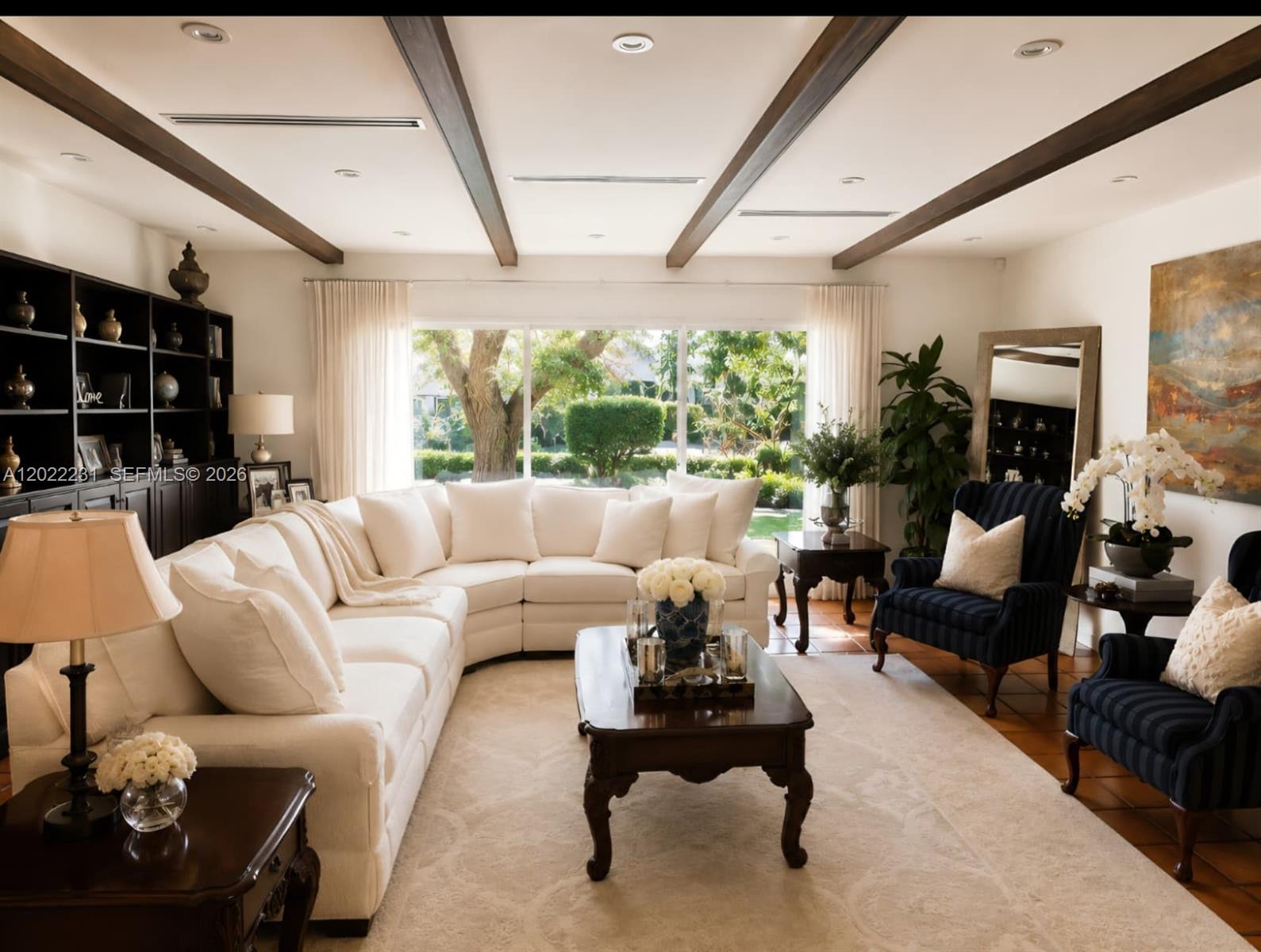 A living room features a large white sectional, dark wood beams, and blue striped chairs — 7980 SW 52nd Ave, Miami FL 33143, MIAMI, FL