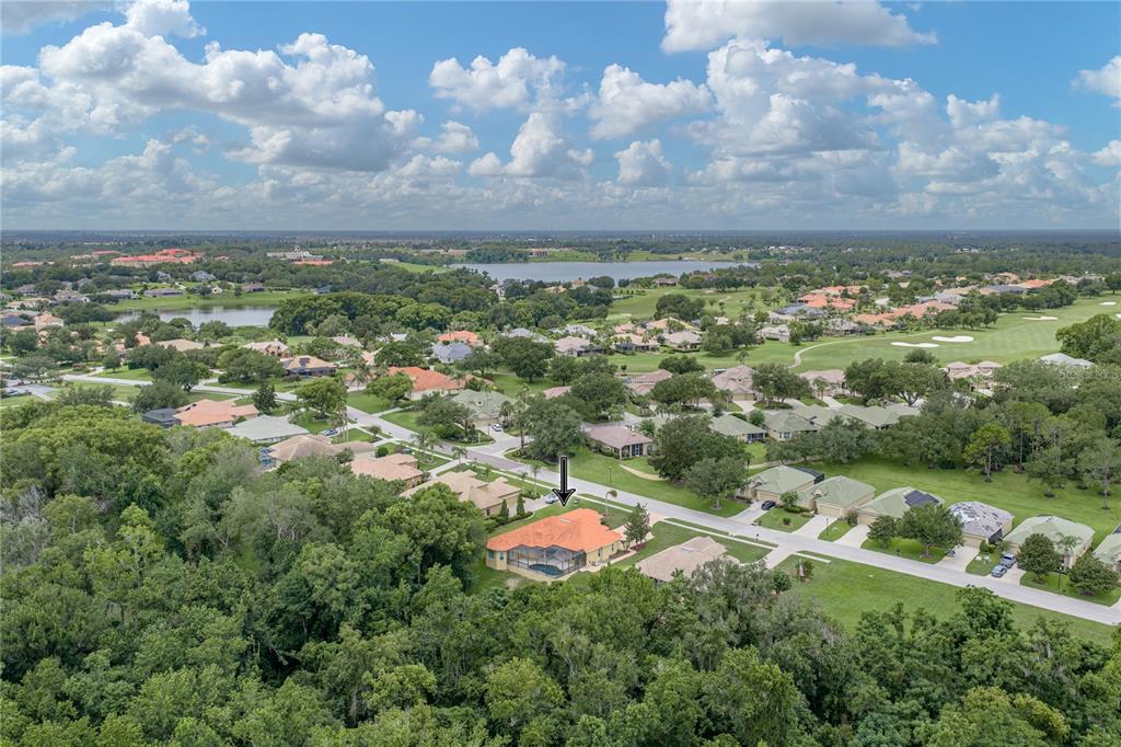 An aerial view shows a house with an orange roof and pool in a neighborhood — 13140 TRADITION DRIVE, DADE CITY, FL