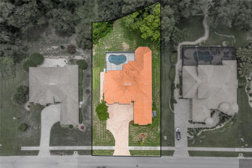 An aerial view shows a house with a red tile roof and a backyard pool — 13140 TRADITION DRIVE, DADE CITY, FL