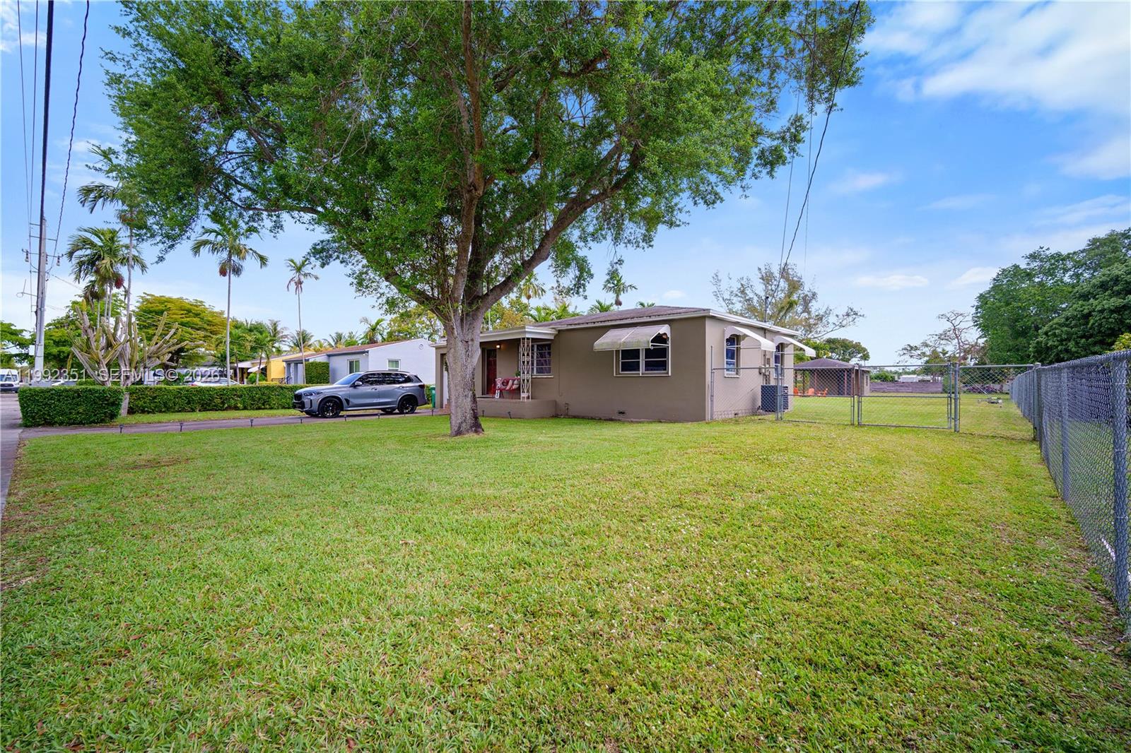 A single-story house with a large front yard, a driveway, and a chain-link fence — 14031 NW 5th Ave, Miami FL 33168, MIAMI, FL