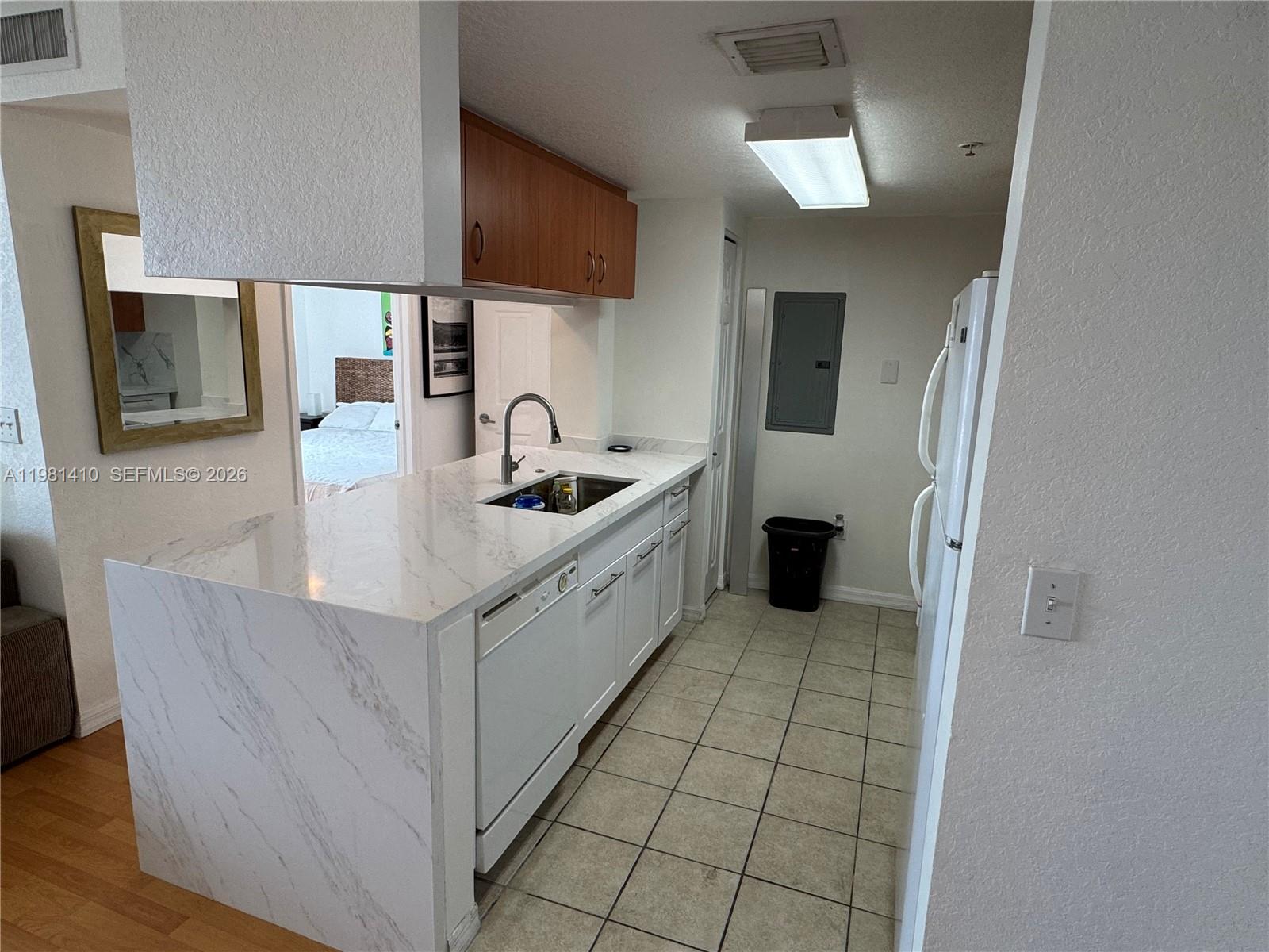 A kitchen features white marble countertops, white cabinetry, a dishwasher, and tiled flooring — 816 NW 11th St # 1108, Miami FL 33136, MIAMI, FL