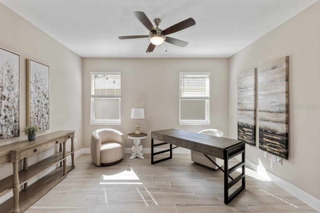 A home office features a wooden desk, two chairs, a console table, and tile flooring — 4529 NW 53RD AVENUE ROAD, OCALA, FL