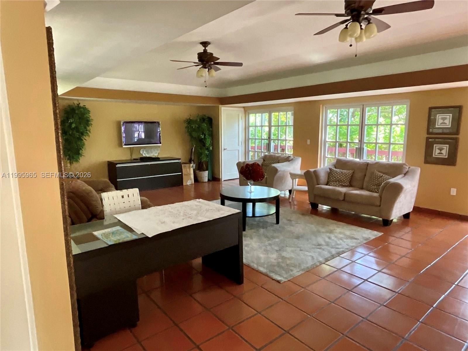 A living room features tile flooring, two ceiling fans, and a beige sofa set — 9998 NOB HILL PL # 9998, Sunrise FL 33351, SUNRISE, FL
