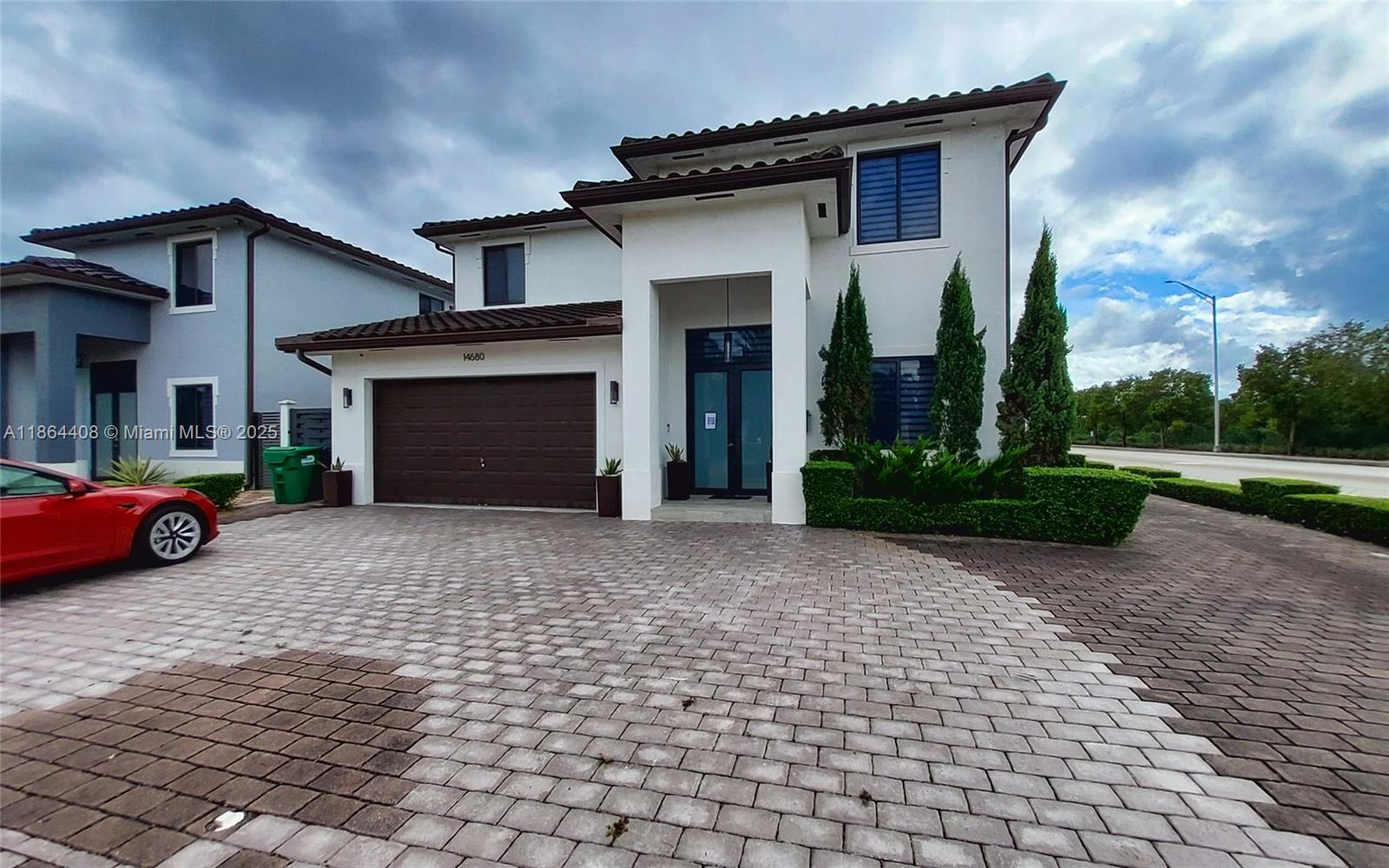 A two-story house features a brown garage door, a paved driveway, and manicured landscaping — 14680 SW 17th St, Miami FL 33175, MIAMI, FL