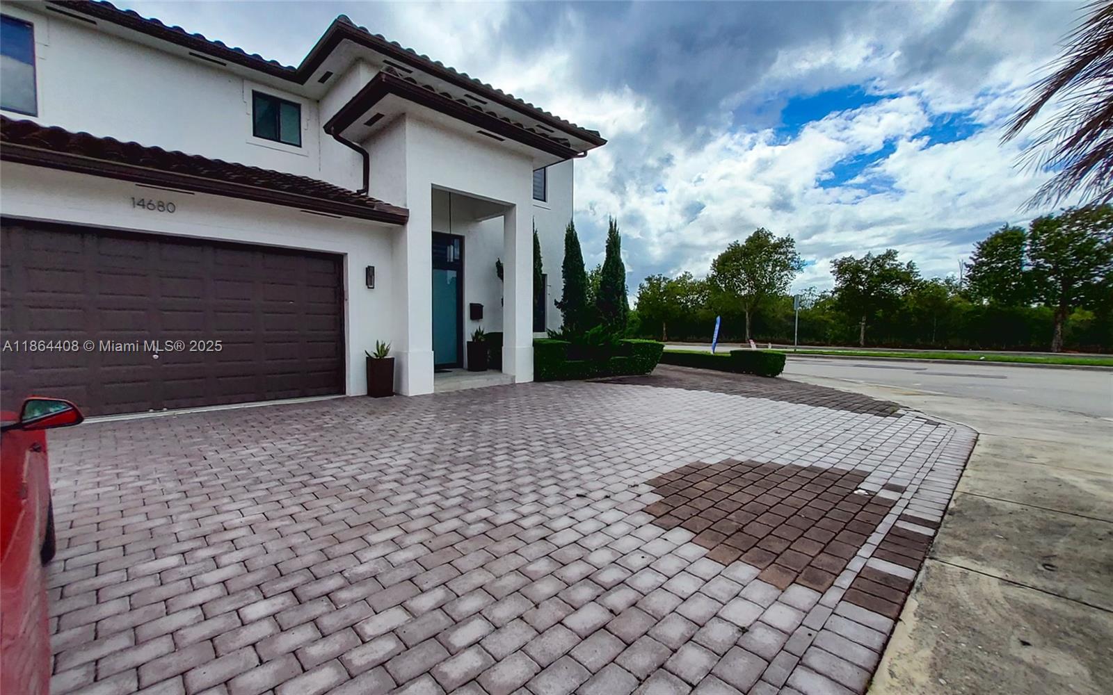 A two-story house features a brown garage door, a paved driveway, and a covered entryway — 14680 SW 17th St, Miami FL 33175, MIAMI, FL