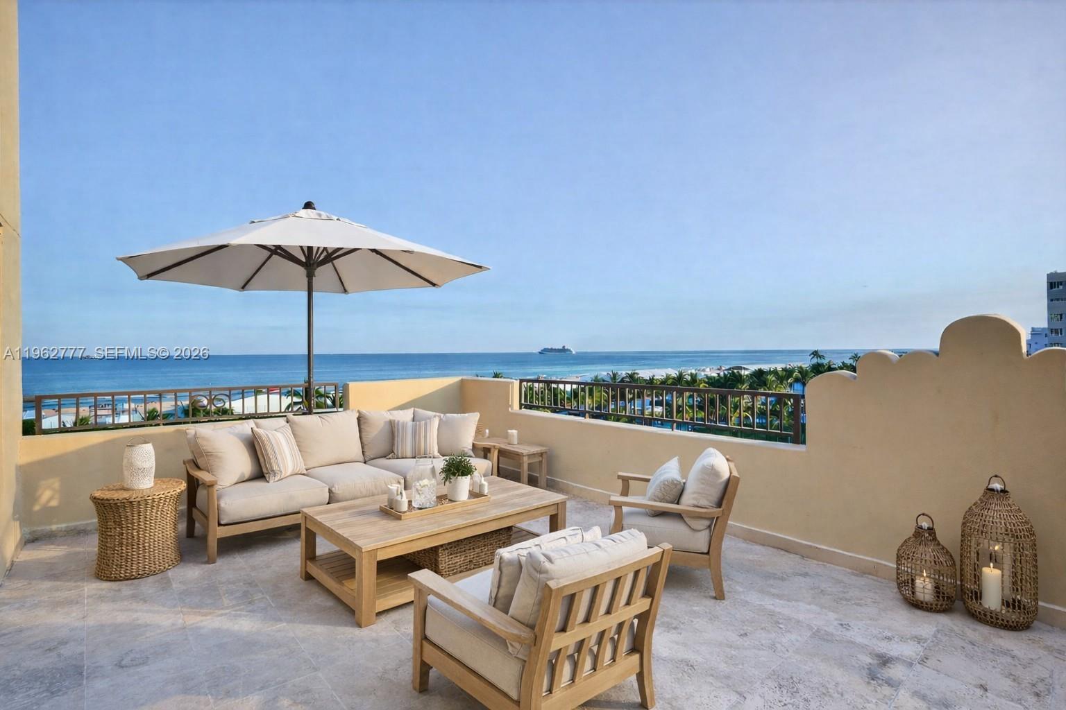 A bright living room features large windows with ocean views, yellow valances, and neutral furniture — 1330 Ocean Dr, Miami Beach FL 33139, MIAMI BEACH, FL