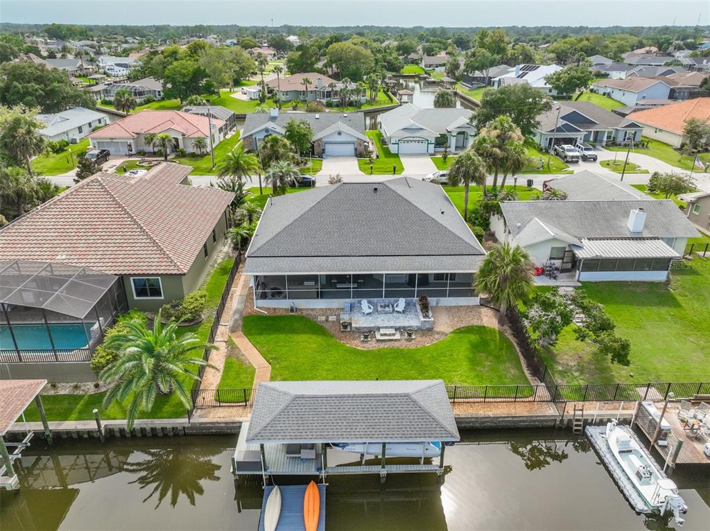 An aerial view shows a house with a screened-in porch, backyard, and private boat dock — 16 CLERMONT COURT, PALM COAST, FL