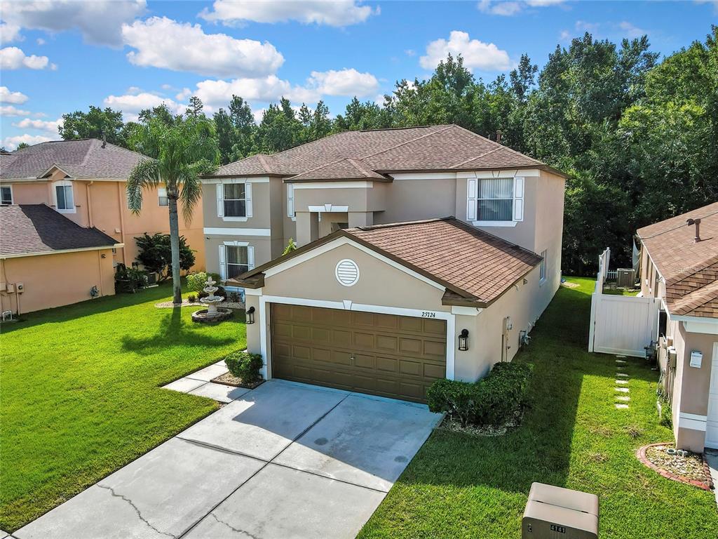 An exterior view of a two-story suburban house with a brown roof and attached garage — 25724 FRITH STREET, LAND O LAKES, FL