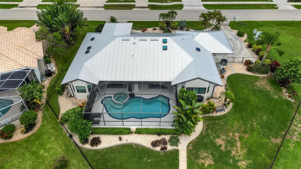 An aerial view of a house with a metal roof and a screened-in swimming pool — 2112 DEBORAH DRIVE, PUNTA GORDA, FL