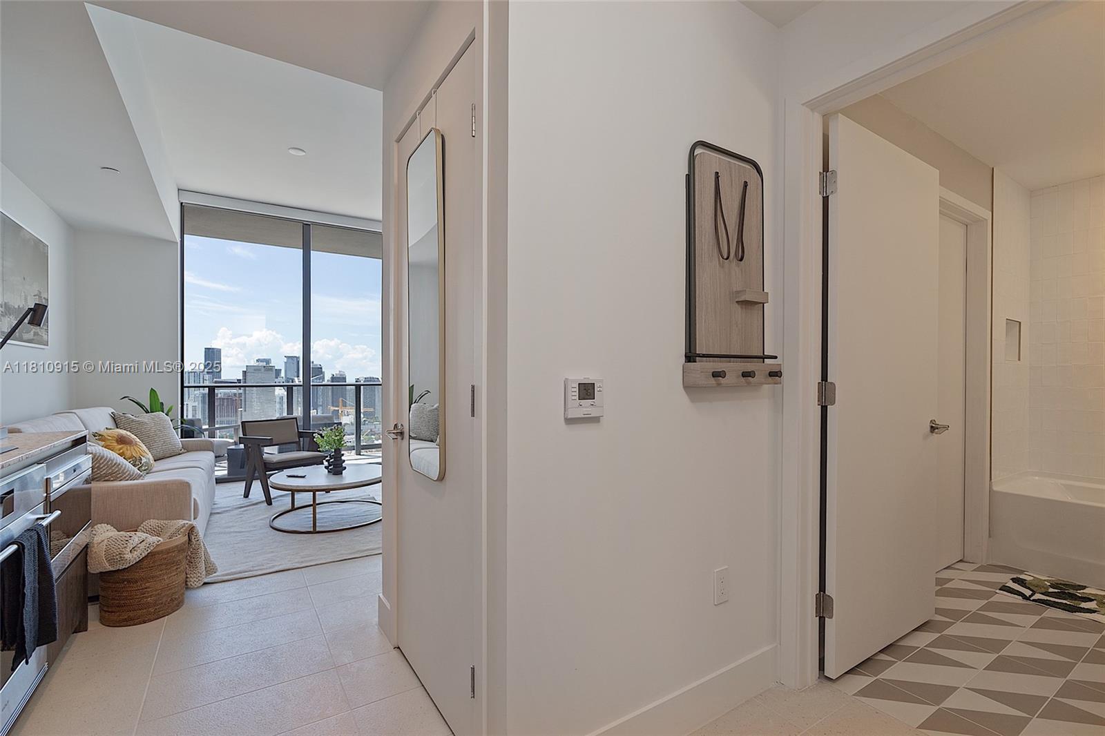 A hallway leads to a living room with floor-to-ceiling windows and an adjacent bathroom — 601 NE 1st Ave # 5007, Miami FL 33132, MIAMI, FL