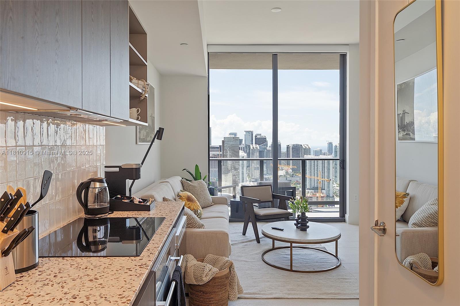 A modern kitchen and living area with a city view through floor-to-ceiling windows — 601 NE 1st Ave # 5007, Miami FL 33132, MIAMI, FL