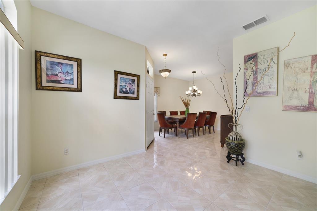 A dining room with a table and chairs is visible from a tiled entryway — 8376 PORT LANCASHIRE DRIVE, ORLANDO, FL