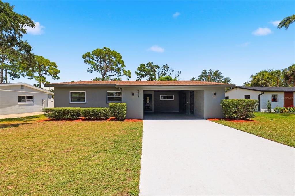 A single-story house with a gray exterior, a flat roof, and an attached carport — 4435 HUNTINGTON STREET NE, ST PETERSBURG, FL