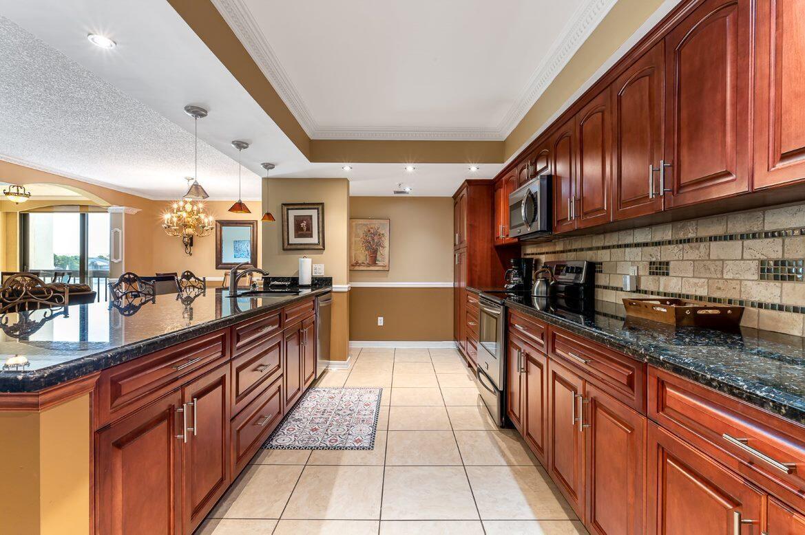 A kitchen with dark wood cabinets, granite countertops, and tile flooring — 1915 Lavers Circle, Delray Beach FL 33444, DELRAY BEACH, FL