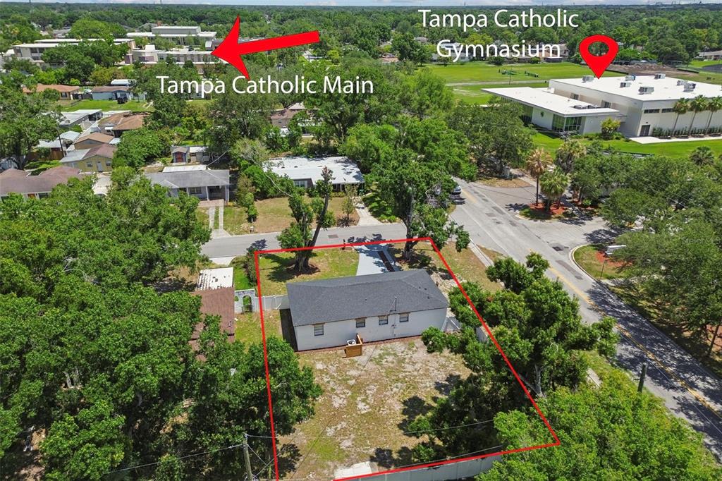 An aerial view shows a single-story house outlined in red near a school campus — 1702 W JOHNSTON AVENUE, TAMPA, FL