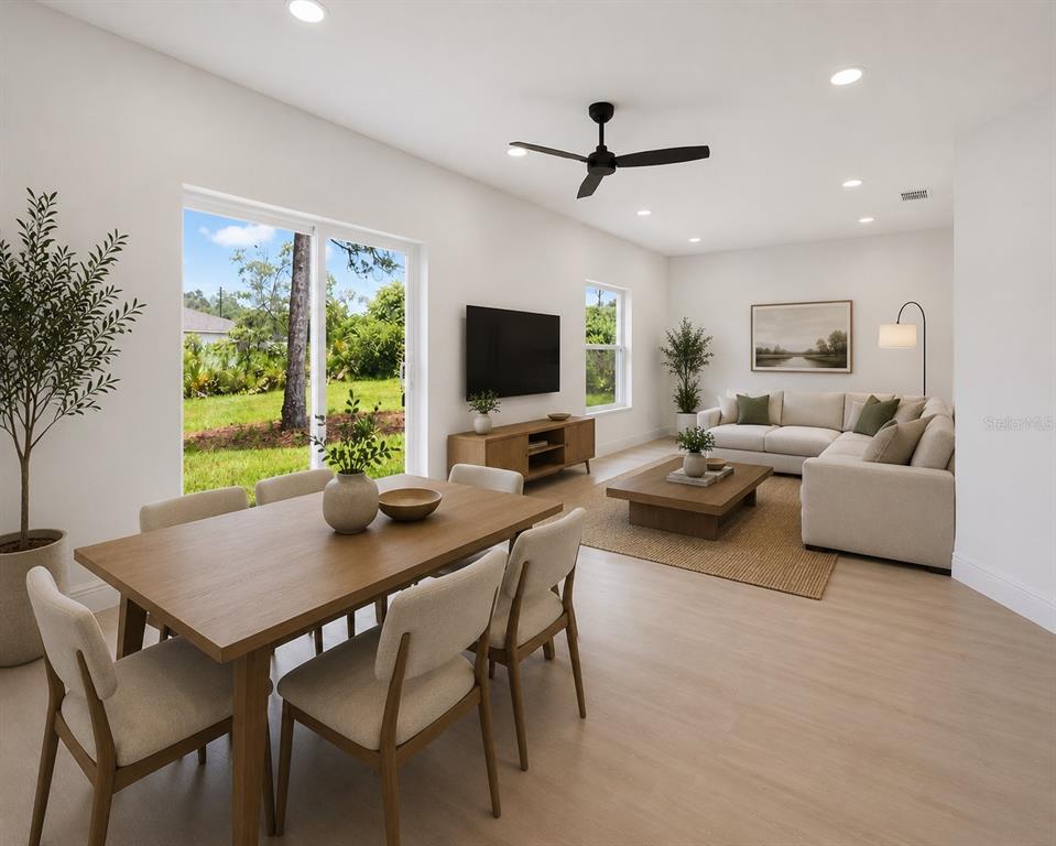 This rendering shows an open-concept living and dining area with light wood floors and furniture — 995 9TH AVENUE, DELAND, FL