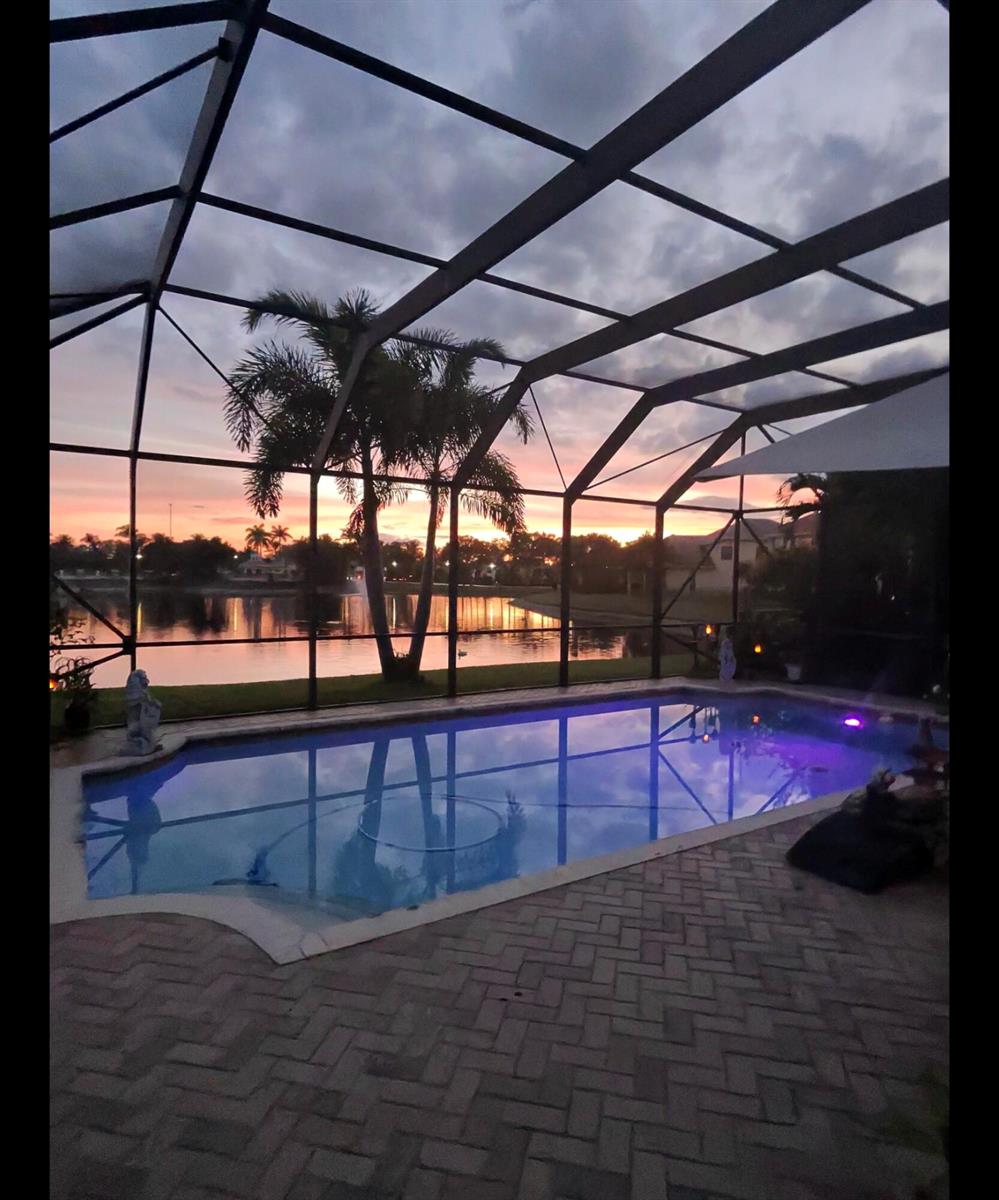 A kitchen features white cabinets, marble-patterned quartz countertops, and a gray tiled backsplash — 10334 Medicis Place, Wellington FL 33449, WELLINGTON, FL