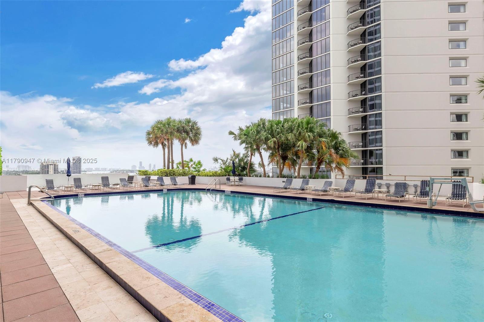 An outdoor swimming pool with lounge chairs sits on a terrace beside a high-rise building — 1717 N Bayshore Dr # 3144, Miami FL 33132, MIAMI, FL