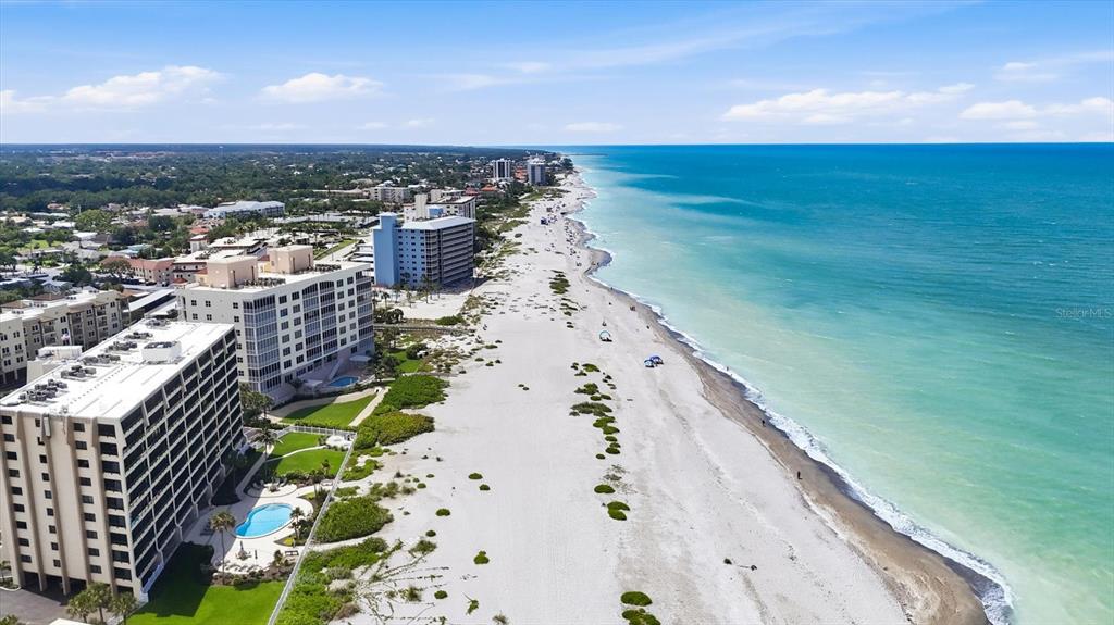 An aerial view shows a sandy beach along the ocean next to several high-rise buildings — 995 LAGUNA DRIVE UNIT 103, VENICE, FL