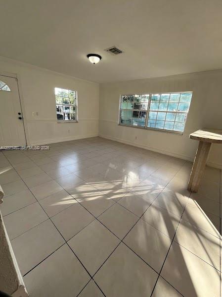 An empty room with white walls, tile flooring, a ceiling light, and two windows — 2411 NW 65th St, Miami FL 33147, MIAMI, FL