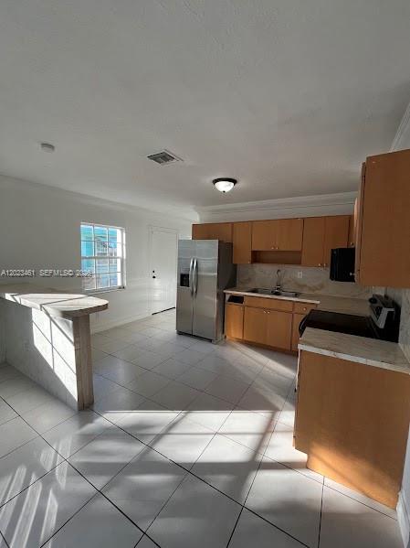 A kitchen with light wood cabinets, stainless steel appliances, and a breakfast bar — 2411 NW 65th St, Miami FL 33147, MIAMI, FL