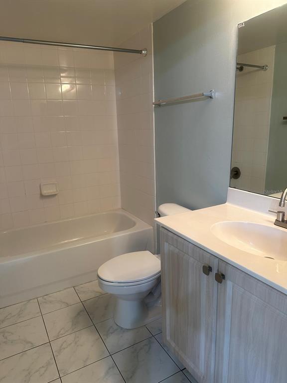 A bathroom features a white bathtub, a toilet, and a vanity with a sink — 1767 FOUR MILE COVE PARKWAY UNIT 810, CAPE CORAL, FL