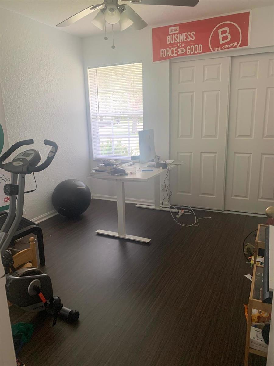 A home office featuring a standing desk, exercise equipment, and wood-look flooring — 4080 Sea Grape Circle, Delray Beach FL 33445, DELRAY BEACH, FL