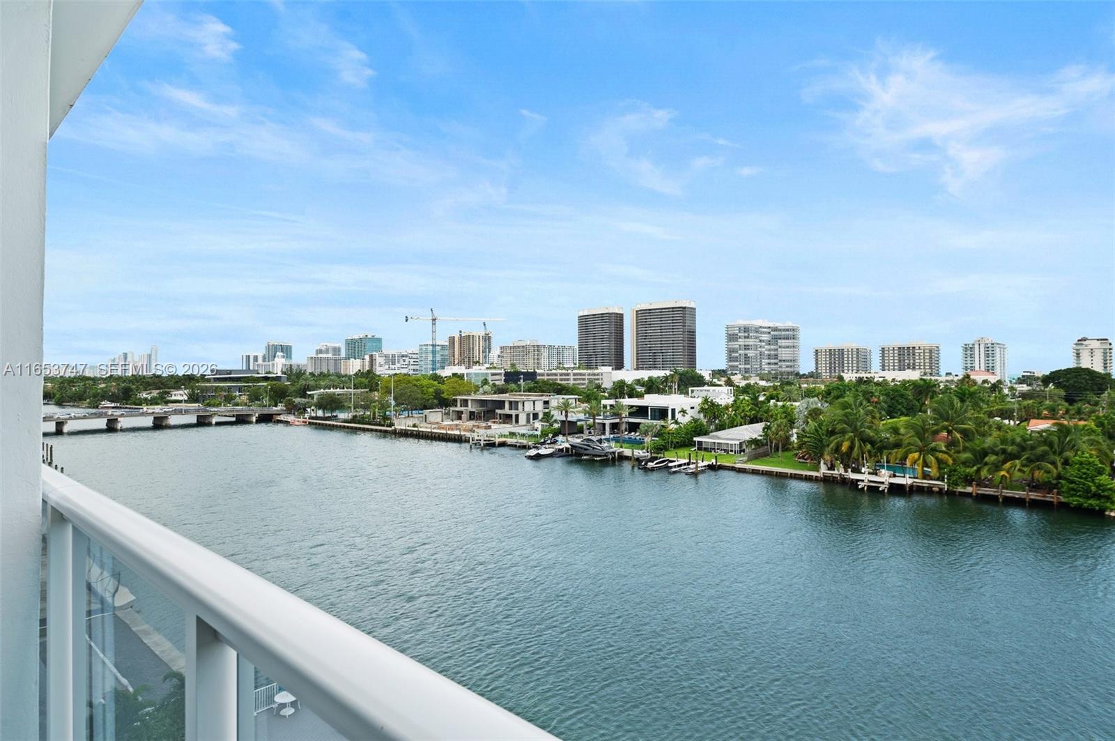 A balcony view overlooks a waterway with boats, a bridge, and a city skyline — 9381 E Bay Harbor Dr # 603S, Bay Harbor Islands FL 33154, BAY HARBOR ISLANDS, FL