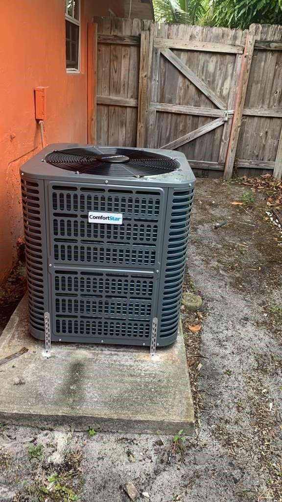 A gray ComfortStar air conditioning unit sits on a concrete pad beside a wooden fence — 2070 NE 2nd Avenue, Pompano Beach FL 33060, POMPANO BEACH, FL