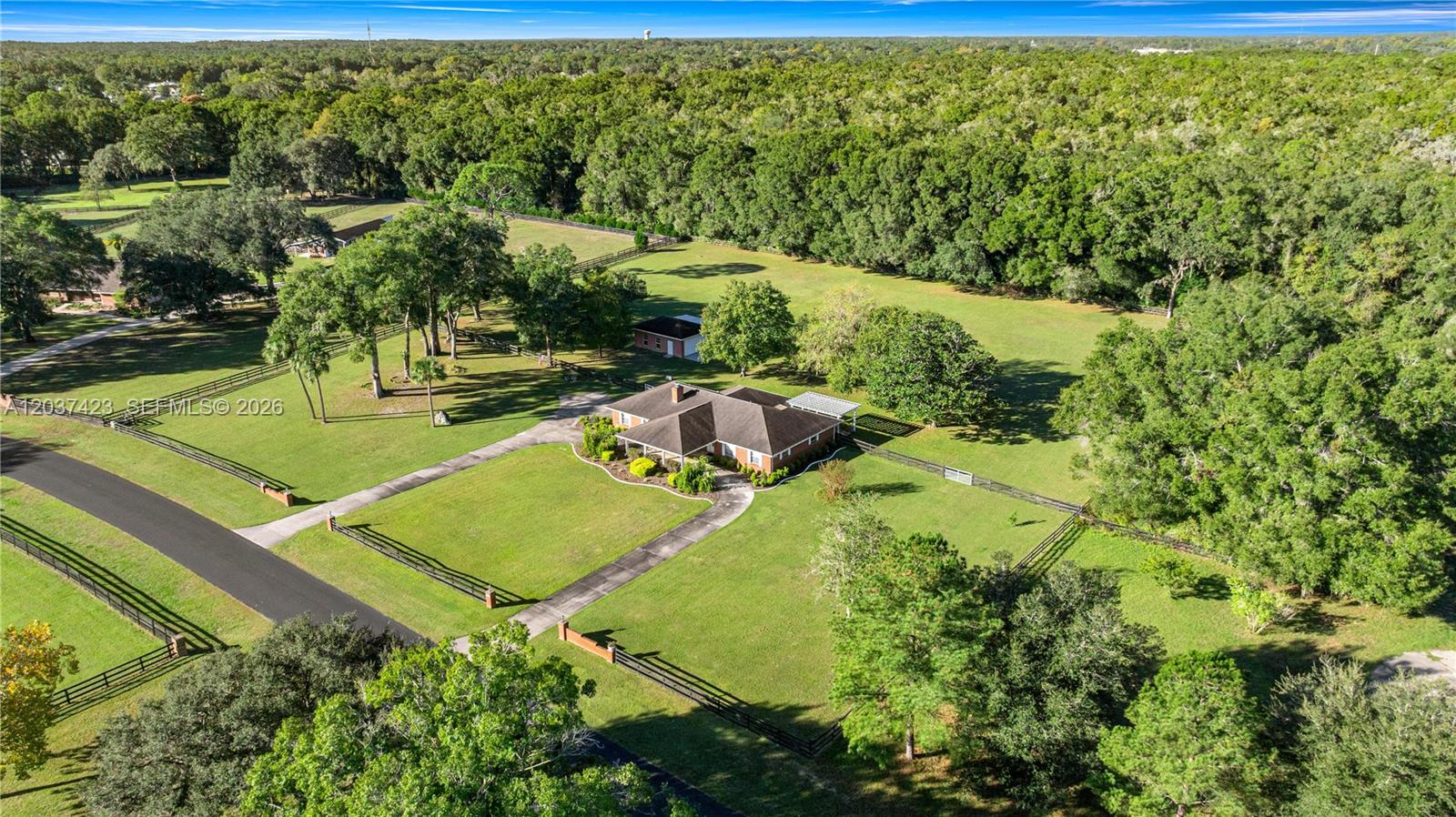 An aerial view shows a single-story house with a driveway on a large, fenced lot — OCALA, FL