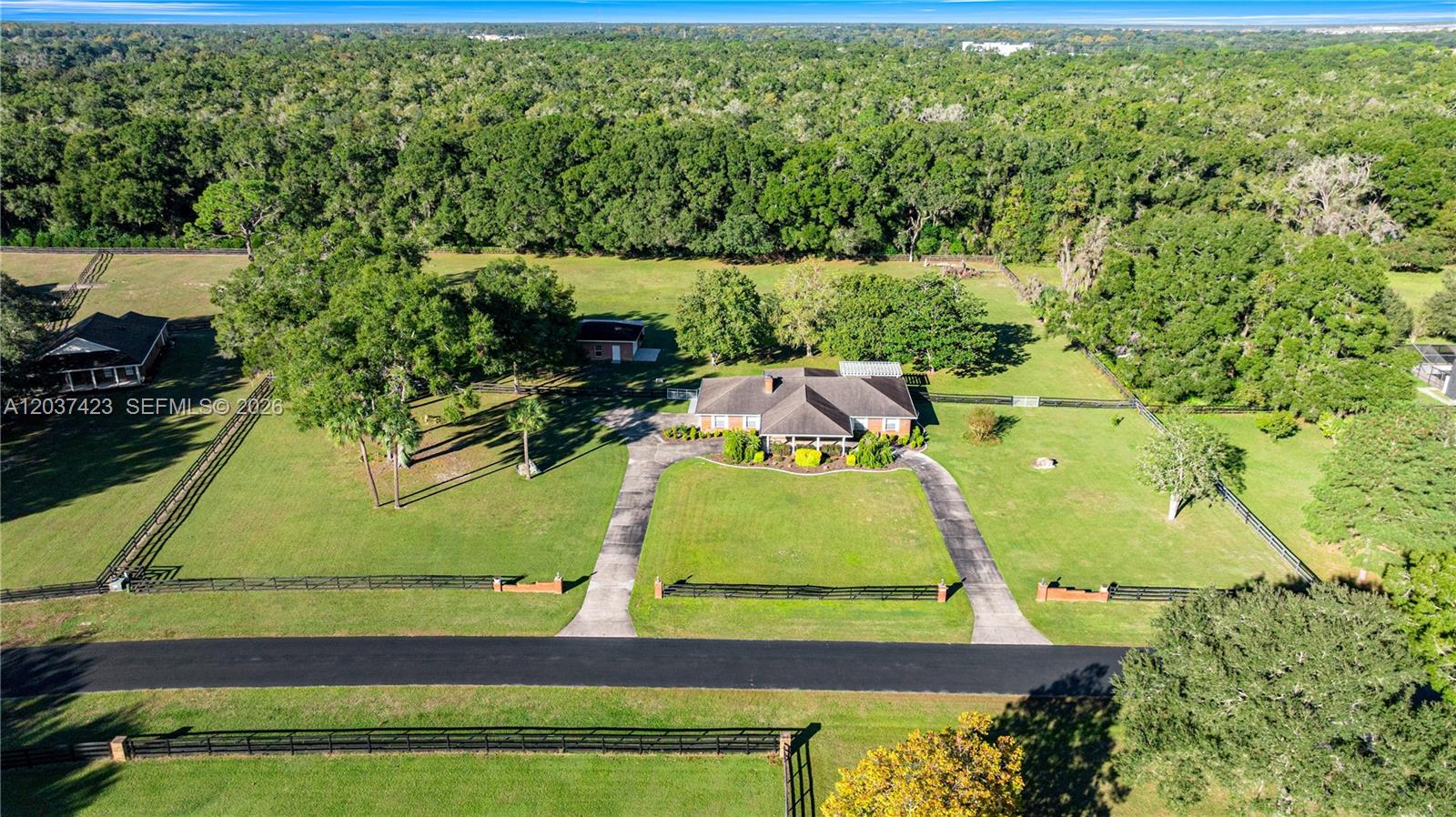 An aerial view shows a single-story house with a circular driveway on a large lot — OCALA, FL