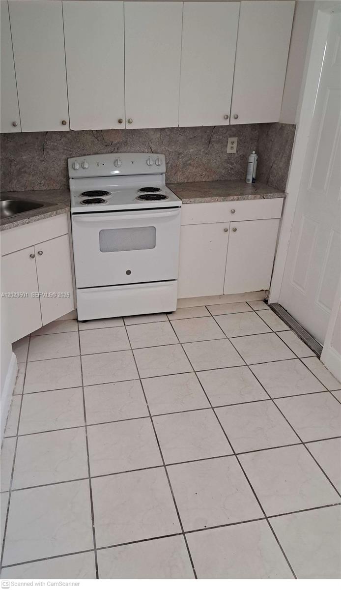A kitchen features white cabinets, a white electric stove, and light-colored tiled flooring — 1362 SW 2nd St # 7, Miami FL 33135, MIAMI, FL