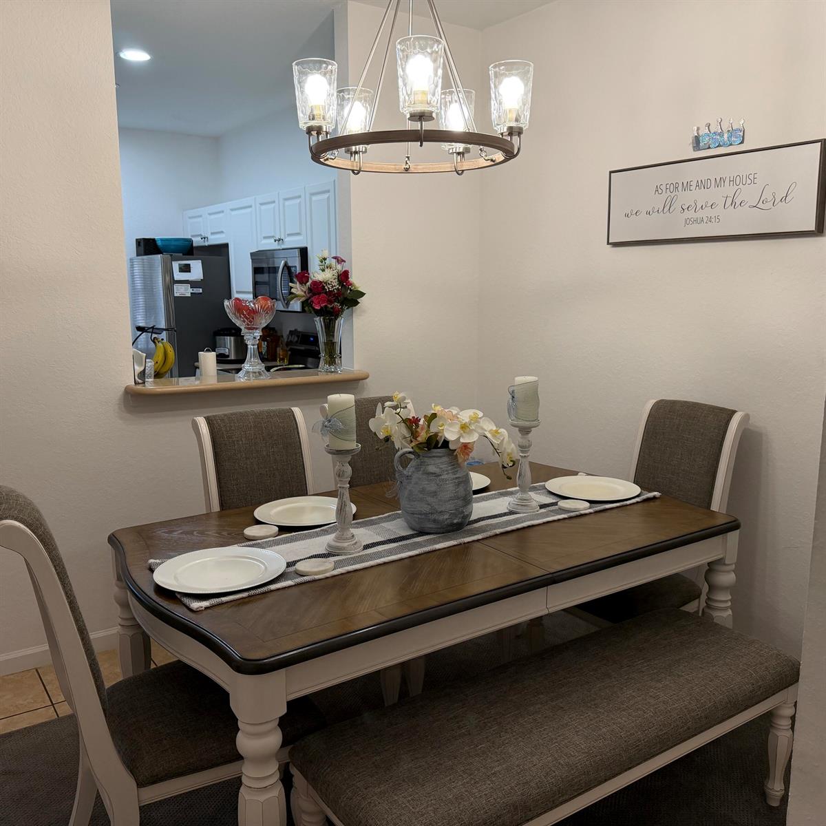 A dining room features a wooden table with chairs and a bench under a chandelier — 976 Abaco Lane, West Palm Beach FL 33404, WEST PALM BEACH, FL