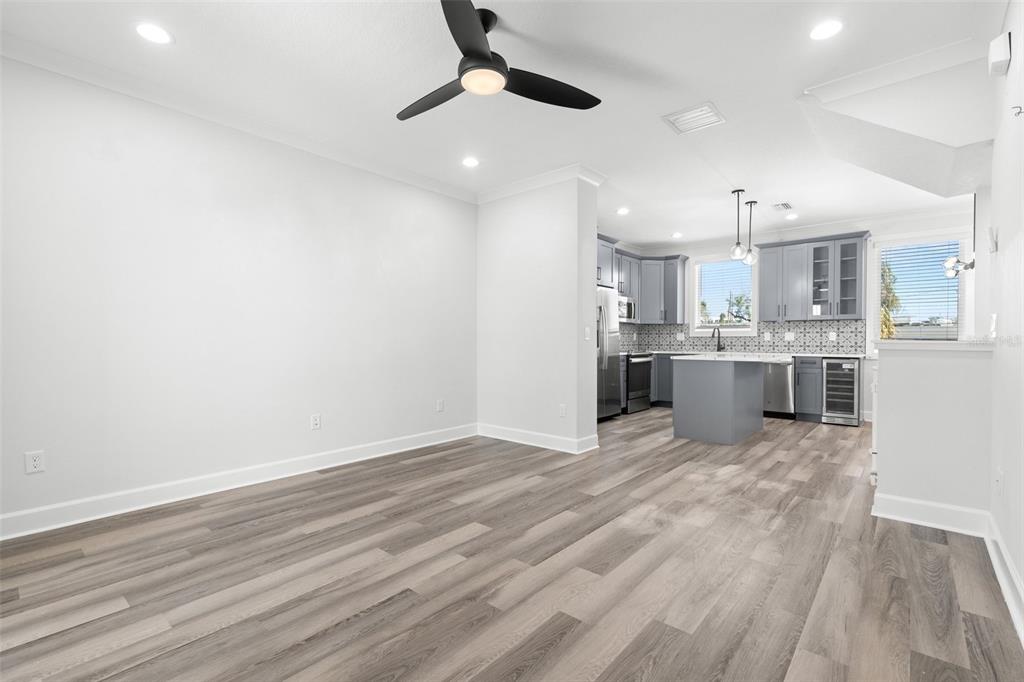 A bright, open-concept kitchen and dining area featuring gray cabinetry and wood-look flooring — 1501 N MORGAN STREET UNIT 5, TAMPA, FL