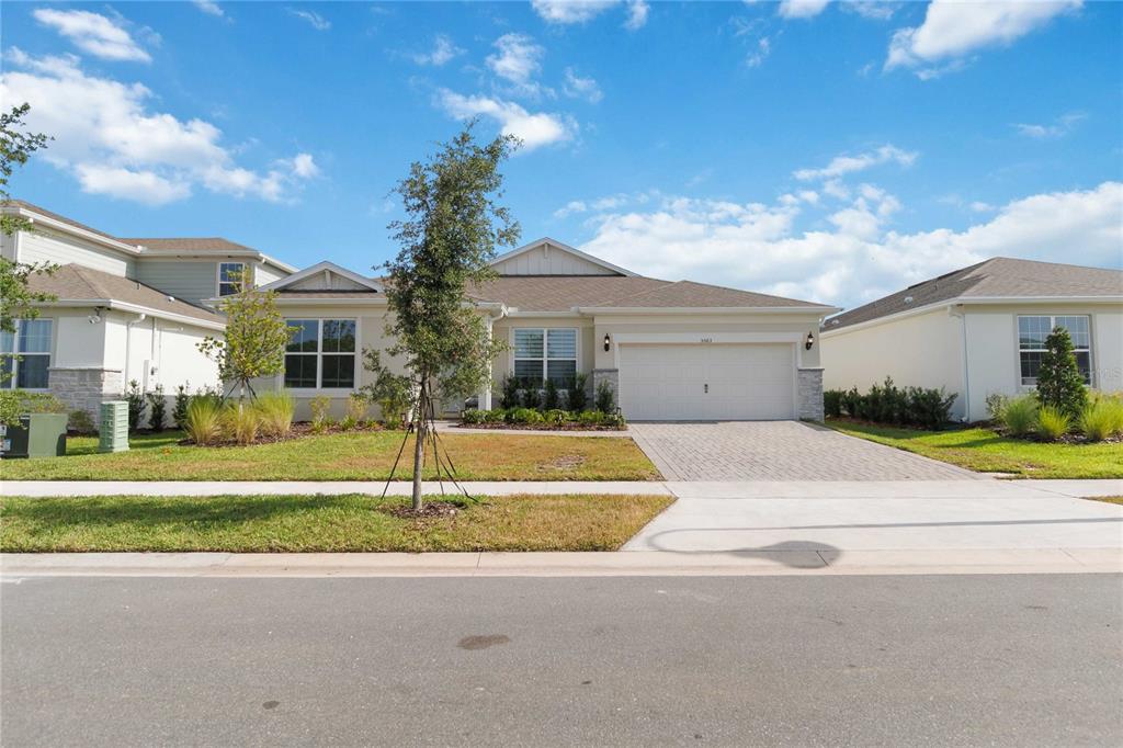 A single-story suburban house with a two-car garage and a paved driveway — 5503 BANYAN BAY ROAD, ST CLOUD, FL