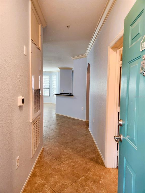 An entryway leads into a tiled living area with a kitchen counter in the distance — 2733 VIA CIPRIANI UNIT 810A, CLEARWATER, FL