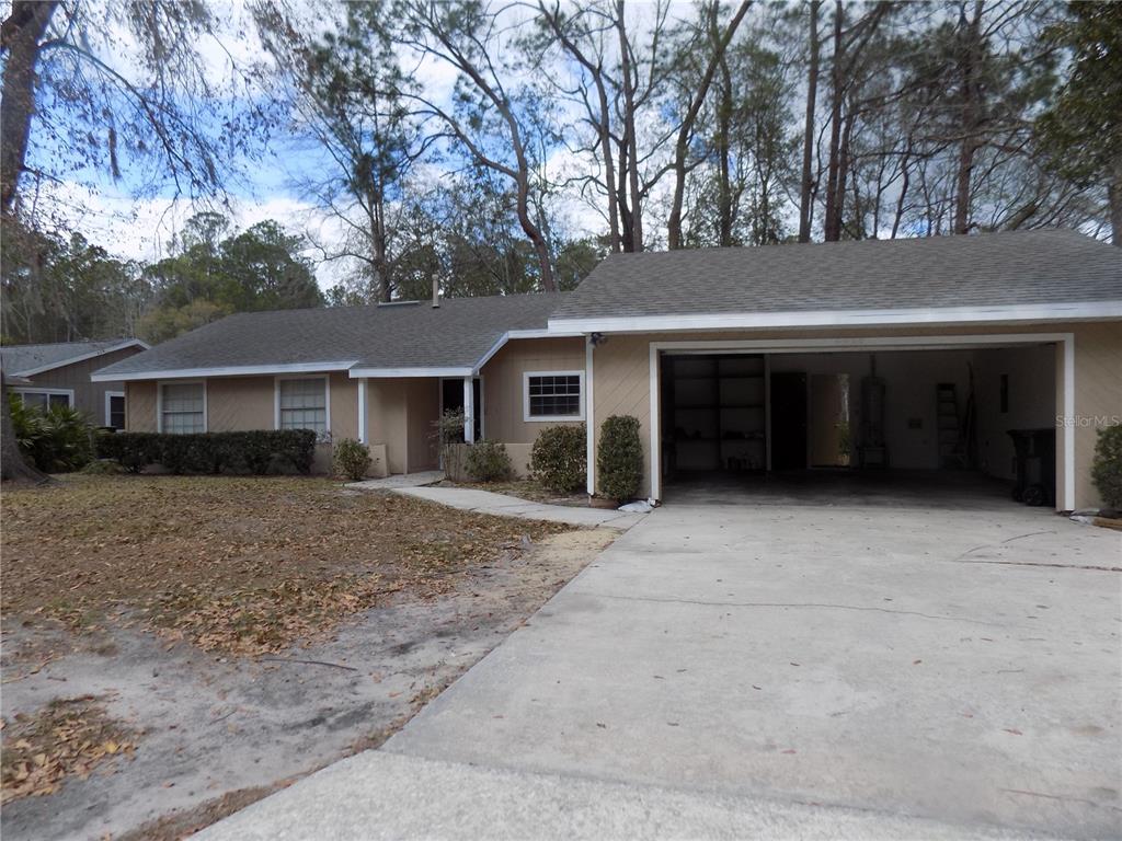 A single-story house with a beige exterior, a two-car garage, and a concrete driveway — 4408 NW 44 PLACE NW, GAINESVILLE, FL